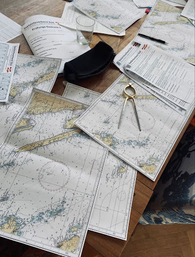 Marine navigation charts and plotting tools on a table, representing marine navigation charts online in Australia.